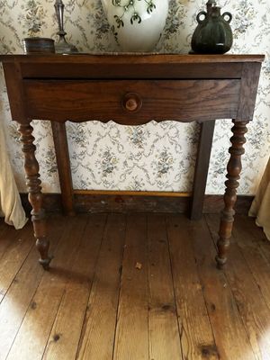 une table en bois sur laquelle se trouve un vase