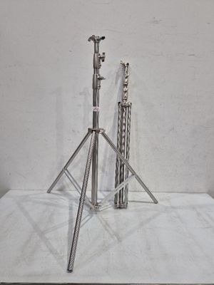 un trépied en argent et un socle en argent posés sur une surface blanche