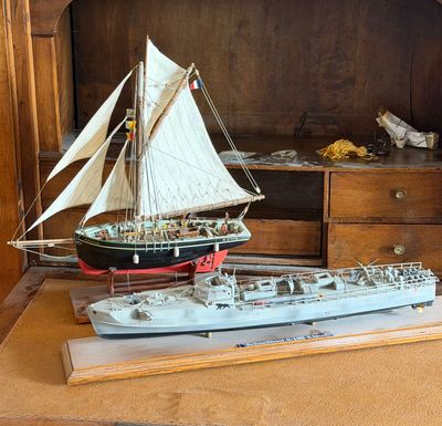 a model of a ship and a model of a boat on a table