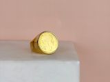 a gold coin ring sitting on top of a marble block
