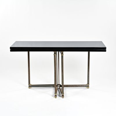 une table noire avec deux pieds en laiton et un plateau noir