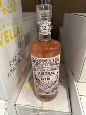 une bouteille de gin Mistral posée sur une boîte