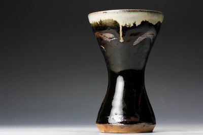 un vase noir et blanc posé sur une table