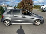 the shadow of a person standing in front of a parked car