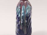 a blue and purple vase sitting on a white surface