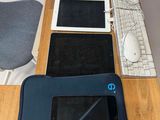 a desk with a laptop, a tablet, a keyboard, and a mouse