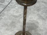 a small metal candle holder sitting on a cement floor