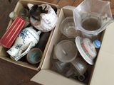 une boîte en carton remplie d'objets divers posée sur un plancher en bois