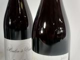 two bottles of wine sitting next to each other on a table