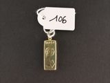 a gold plated pendant with a small piece of gold on it