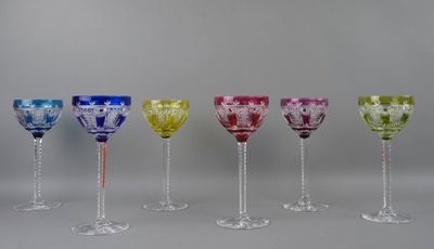 six different colored wine glasses are lined up in a row