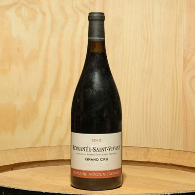 a bottle of wine sitting on top of a wooden barrel