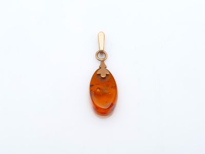 un pendentif en or jaune orné d'une pierre d'ambre de forme ovale