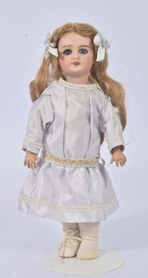porcelain doll of a blonde haired girl in a white dress with a flower in her hair