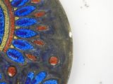 a blue and red plate with a flower design on it
