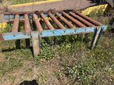 a rusted metal bed in the grass by the road