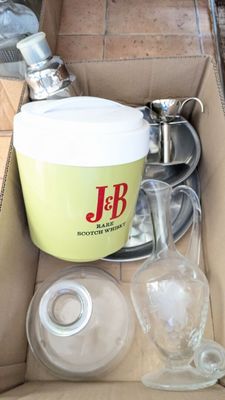 une boîte remplie de verres vides posée par terre