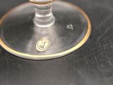 a glass of wine sitting on a table with a gold rim
