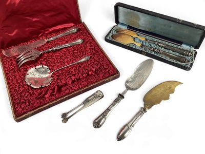 des couverts dans un étui rouge, ainsi qu'un couteau, une fourchette, une cuillère et un repose-couteau