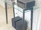 une table en verre sur laquelle est posée une chaîne hi-fi