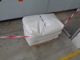 a white box sitting on top of a pallet next to a red and white caution tape