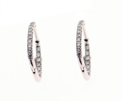 une paire de boucles d'oreilles créoles en diamant sur fond blanc