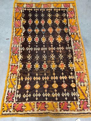 an old rug with a yellow border and a black background