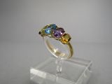 un gros plan d'une bague sertie de trois pierres sur un support transparent