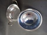silver plate with a silver lid and a silver spoon on a table