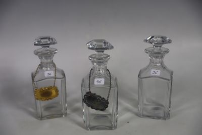 three small glass bottles with gold and silver items in them