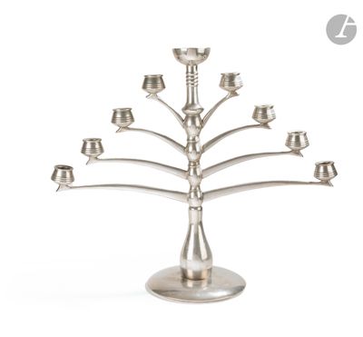 a silver metal candelier with five candles on a stand