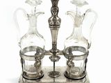 three glass vases on a metal stand with a handle