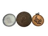 three medals are shown on a white surface with a white background