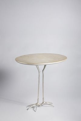 a white table with two legs and a round table top