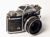 a black and silver camera sitting on a white surface