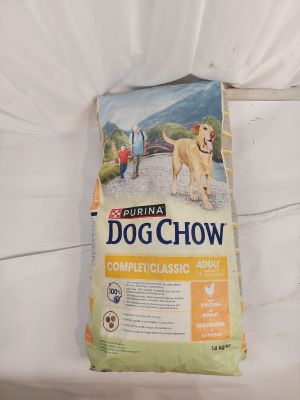 La gamelle du chien est posée sur le lit, à côté de l'oreiller.