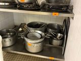 de nombreuses casseroles et poêles sur les étagères de la cuisine