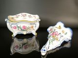 deux pièces de porcelaine sont posées sur une surface noire