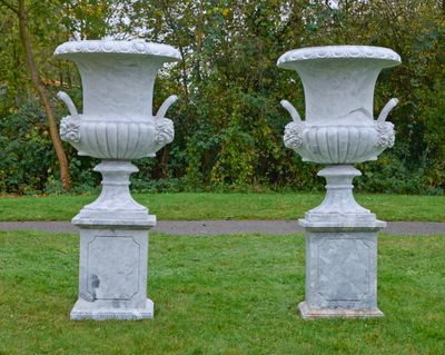 deux vases blancs posés l'un sur l'autre dans l'herbe