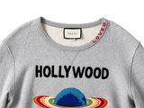the sweatshirt is grey with an image of a planet on it