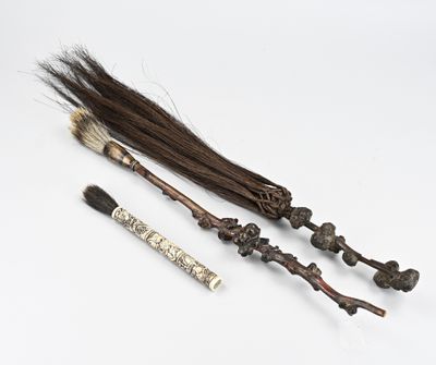 trois types de balais différents et une brosse posés sur une surface blanche