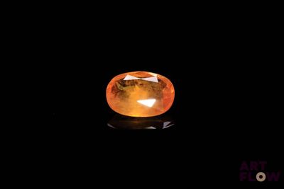 a close up of a yellow sapphire stone on a black background