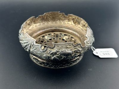 une assiette ancienne en argent avec une étiquette sur un fond noir