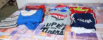 de nombreux t-shirts étalés sur une table dans une pièce