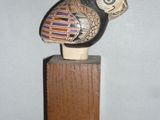 a small wooden object with a bird on top of it