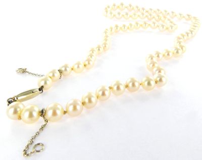 collier avec des perles et un fermoir en or sur fond blanc