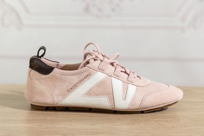 a close up of a pair of pink sneakers on a wooden table