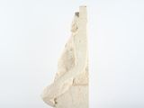 a white sculpture of a man standing on a rock
