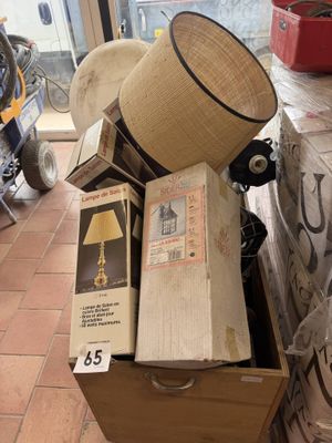 une caisse en bois remplie de boîtes, surmontée d'une lampe