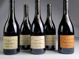 six bouteilles de vin sont alignées sur une table